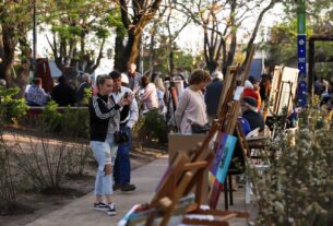 Visitantes disfrutando de la exposición de arte “CarapArt” en Carapachay, observando diversas obras y participando en actividades culturales en un ambiente al aire libre.