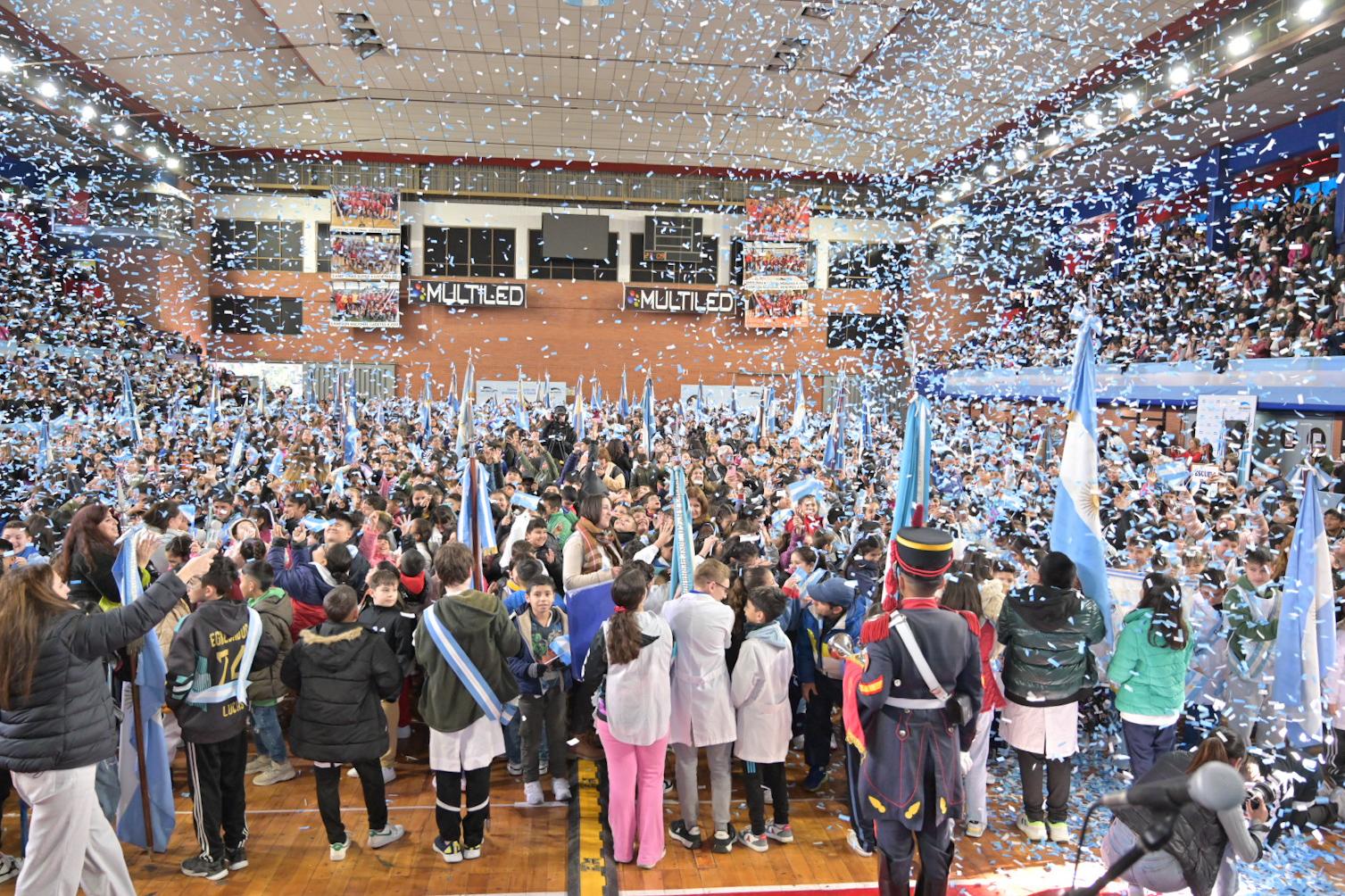 Estudiantes de San Martín realizando la promesa de lealtad a la bandera argentina en la Sociedad Alemana de Gimnasia de Villa Ballester, acompañados por el intendente Fernando Moreira y otros funcionarios.