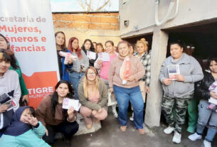 Un grupo de mujeres y niñas participan en el programa "Tigre se COPA" en el barrio Almirante Brown, sosteniendo material informativo y copas menstruales.