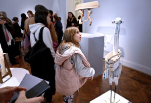 Visitantes observando la exhibición 'Faunobotes. La Leyenda' en el Museo de Arte Tigre, con esculturas hechas de madera reciclada por el artista David Klauser.