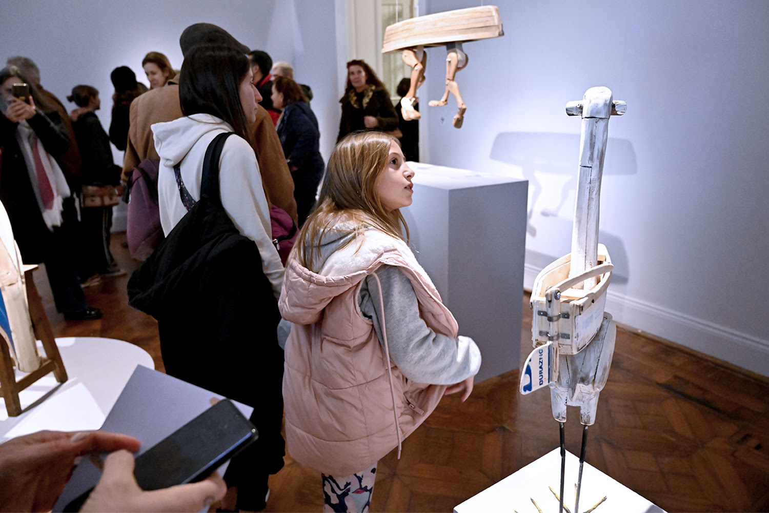 Visitantes observando la exhibición 'Faunobotes. La Leyenda' en el Museo de Arte Tigre, con esculturas hechas de madera reciclada por el artista David Klauser.