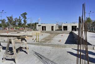 Obreros trabajando en la construcción de un nuevo natatorio en General Pacheco, con estructuras de concreto y paredes en construcción visible, supervisado por el intendente Julio Zamora.