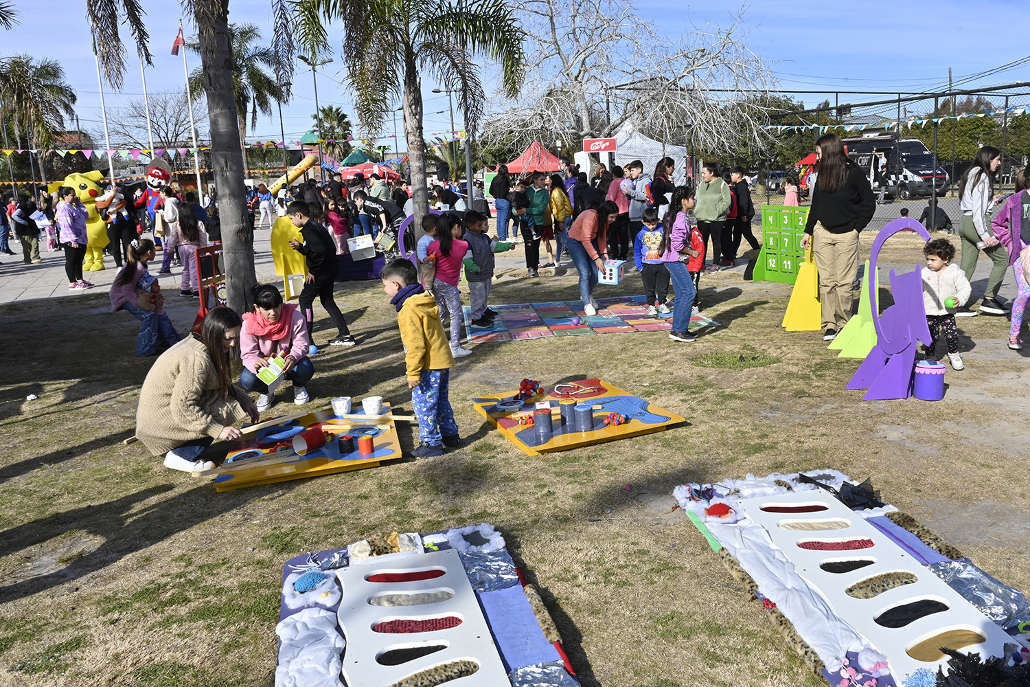 Niños y niñas participando en diversas actividades recreativas al aire libre durante el programa Diversión en las Plazas en Benavídez, organizado por el Municipio de Tigre.