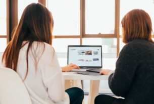 Dos mujeres utilizando una computadora portátil durante un curso de capacitación en inteligencia artificial.