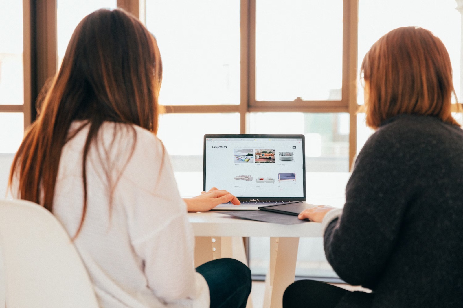 Dos mujeres utilizando una computadora portátil durante un curso de capacitación en inteligencia artificial.