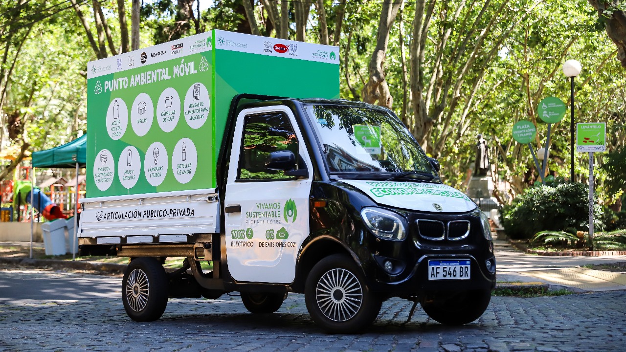 El Punto Ambiental Móvil de Vicente López, un vehículo 100% eléctrico, estacionado en una plaza mientras recoge diversos materiales reciclables.