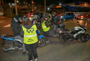 Operativo de seguridad y tránsito en San Martín y San Isidro, con agentes de tránsito revisando documentación de motociclistas en una intersección, con vehículos y patrulleros en el fondo.