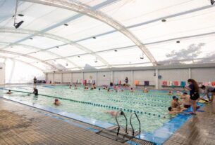 Piscina cubierta del Campo de Deportes Nº4 en Martínez, San Isidro, con personas de distintas edades practicando natación y gimnasia acuática tras las remodelaciones realizadas por el municipio.