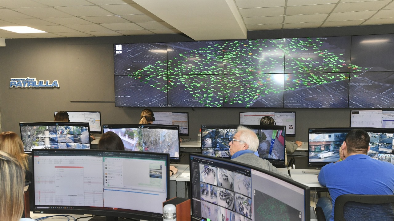 Centro de monitoreo de Vicente López mostrando múltiples pantallas de vigilancia y un mapa del área con indicadores de cámaras instaladas.